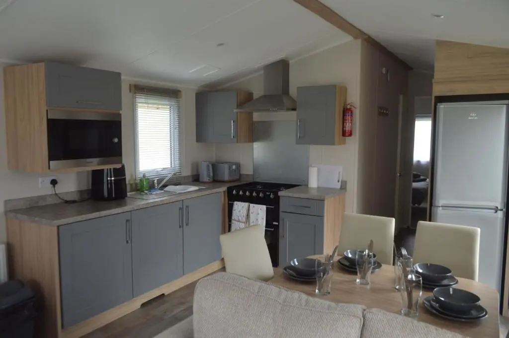 a kitchen with a table and chairs and a kitchen with at B9 at The Old Mill Holiday Park in Dyke