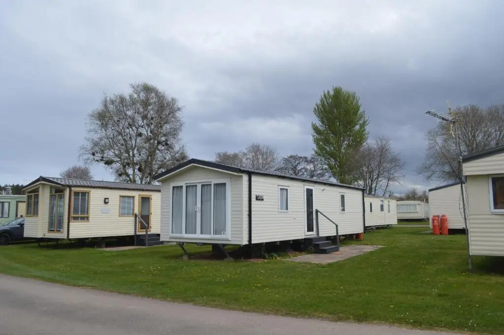 a row of mobile homes parked in a park at B9 at The Old Mill Holiday Park in Dyke
