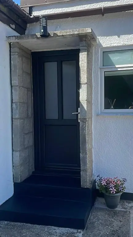 a black door on a house with a window at 51 Island Bank in Inverness