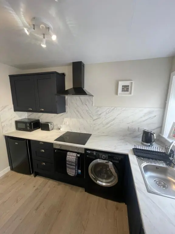 a kitchen with a washing machine next to a sink at 51 Island Bank in Inverness