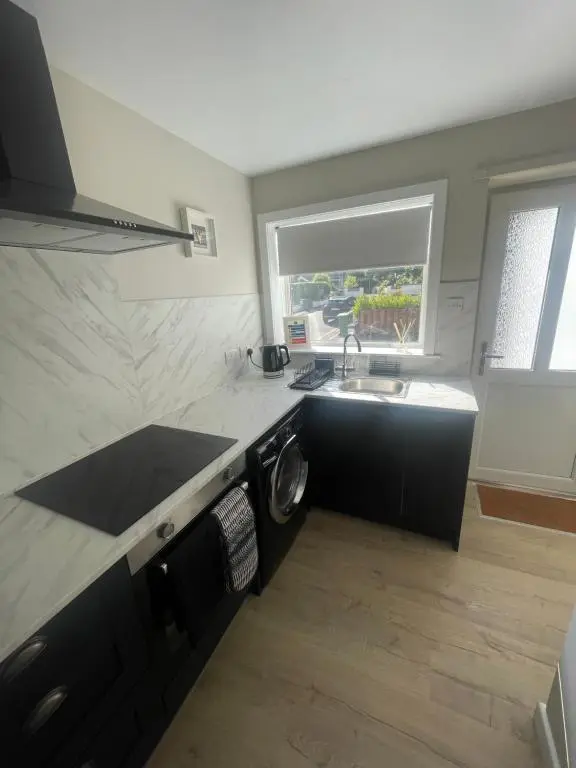 a kitchen with a sink and a washing machine at 51 Island Bank in Inverness
