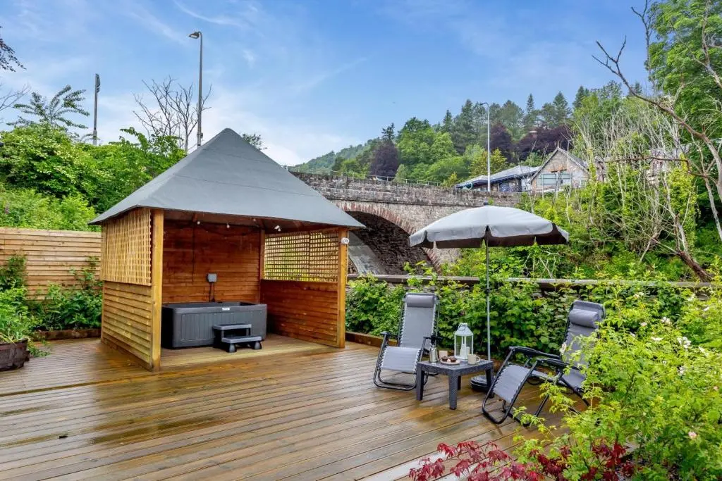 a wooden deck with a gazebo in a garden at 1 Bed in Drumnadrochit oc-t32404 in Drumnadrochit