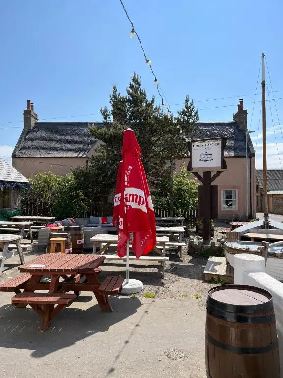 a red umbrella sitting on top of a picnic table at Crown and Anchor Inn in Findhorn