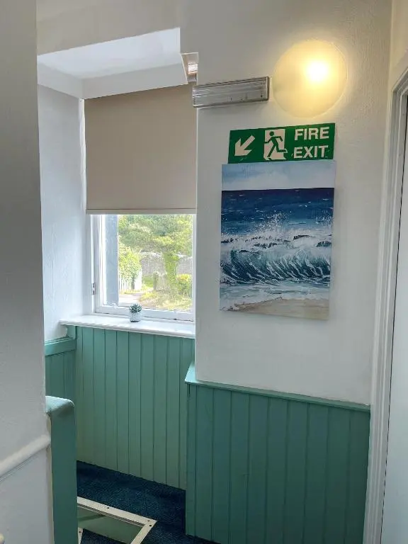 a room with a fire exit sign and a window at Crown and Anchor Inn in Findhorn