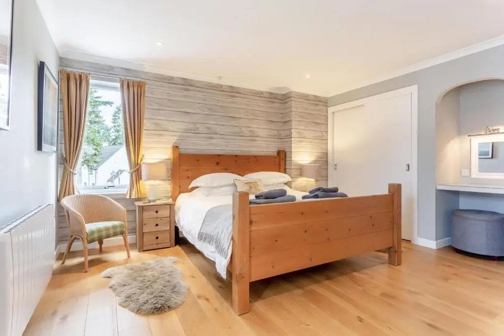 a bedroom with a wooden bed with a wooden headboard at 1 Bed in Newtonmore oc-a32412 in Newtonmore
