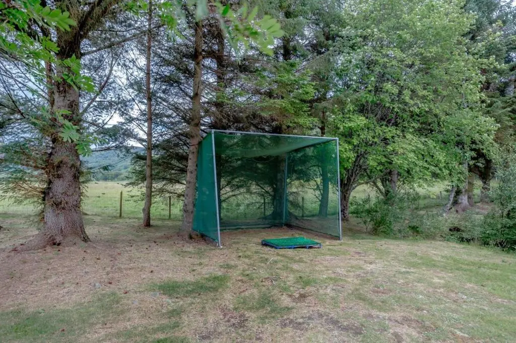 a green tent in a field next to a tree at 2 Bed in Newtonmore oc-d32413 in Newtonmore