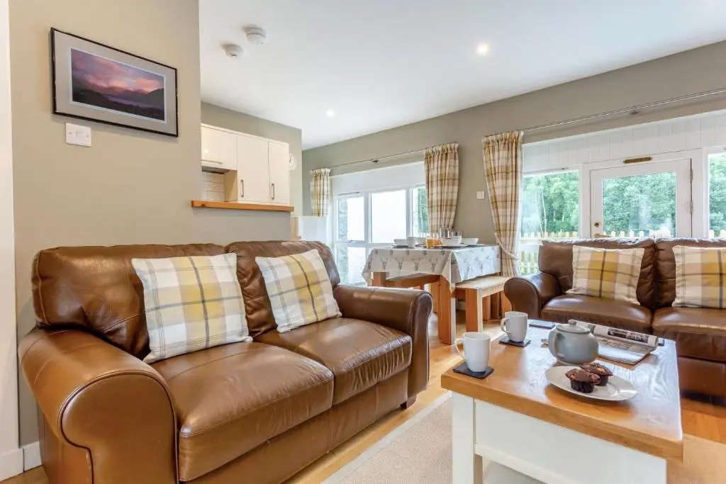 a living room with two leather couches and a table at 2 Bed in Newtonmore oc-d32413 in Newtonmore