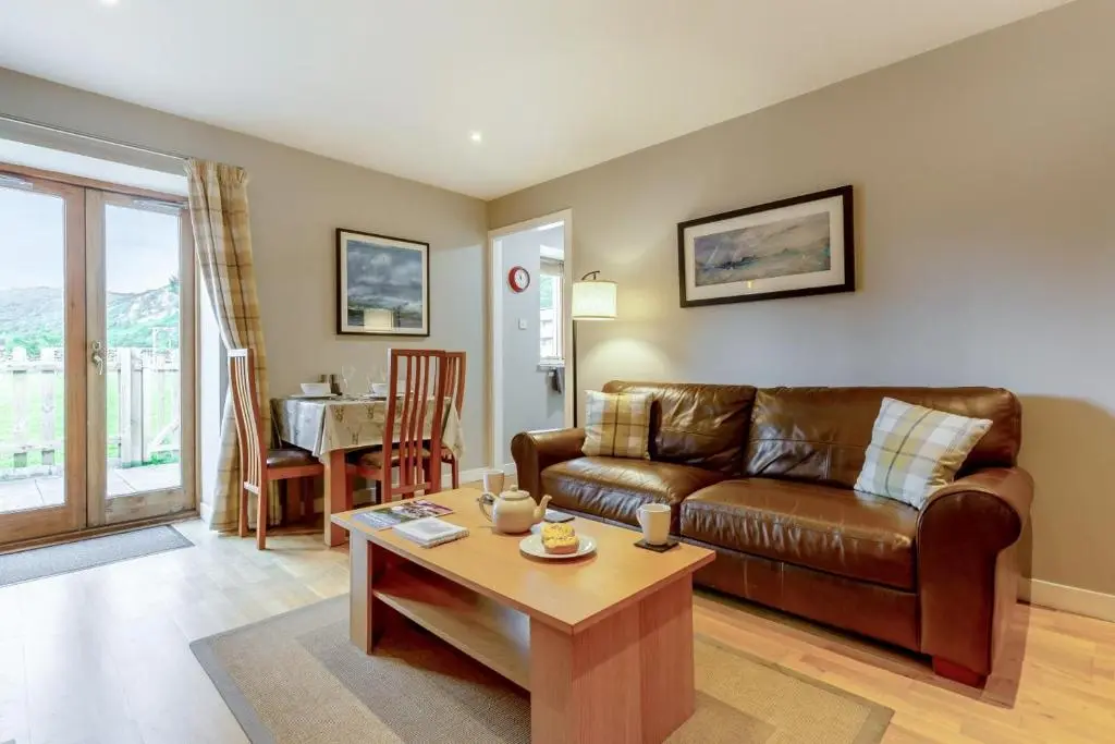 a living room with a couch and a table at 1 Bed in Newtonmore oc-c32414 in Newtonmore