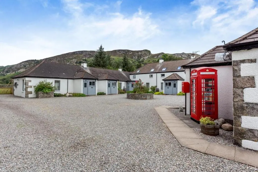 a red phone booth in front of a group of houses at 1 Bed in Newtonmore oc-c32414 in Newtonmore
