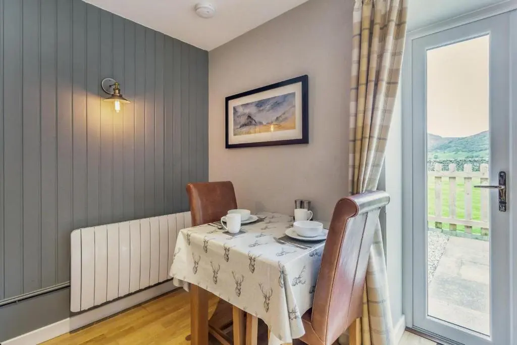 a dining room with a table and chairs and a window at 1 Bed in Newtonmore oc-b32417 in Newtonmore