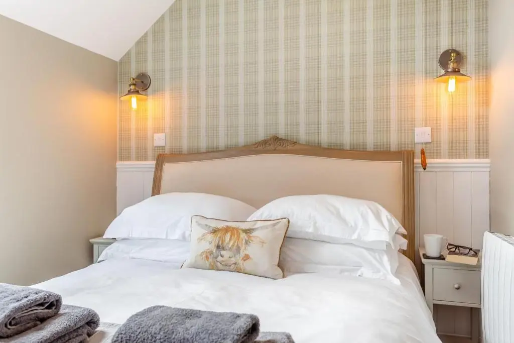 a bed with white sheets and a pillow on it at 2 Bed in Newtonmore oc-e32418 in Newtonmore