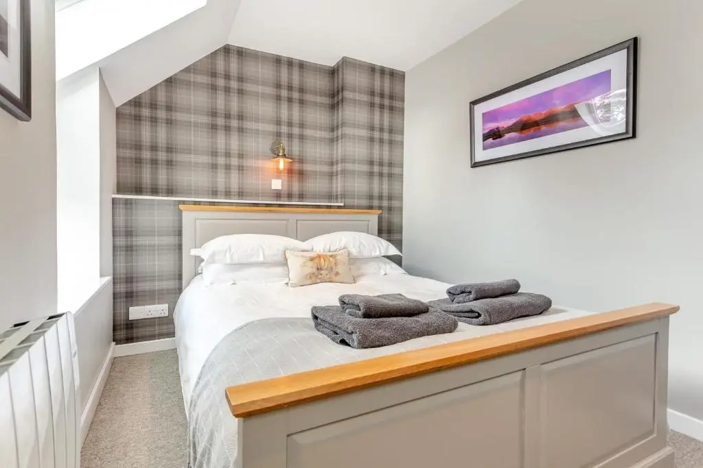 a bedroom with a bed with two towels on it at 3 Bed in Newtonmore oc-h32416 in Newtonmore
