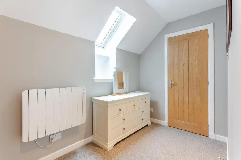 a bedroom with a skylight and a dresser and a door at 3 Bed in Newtonmore oc-h32416 in Newtonmore
