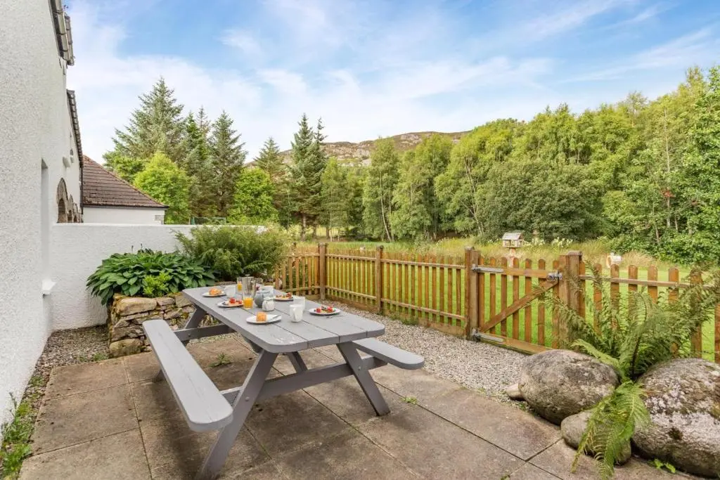 a picnic table in a backyard with a fence at 3 Bed in Newtonmore oc-h32416 in Newtonmore