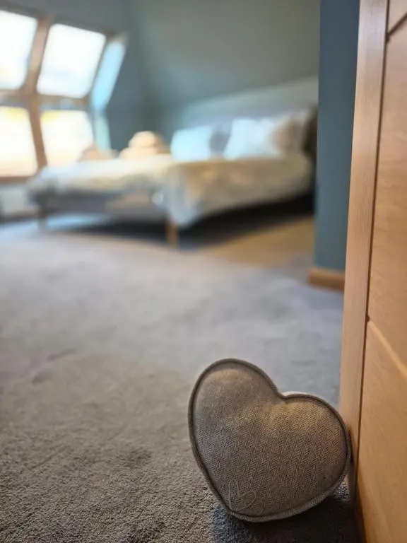 a heart shaped mirror on the floor next to a dresser at 2 Bed House - free parking, short walk to City centre in Inverness
