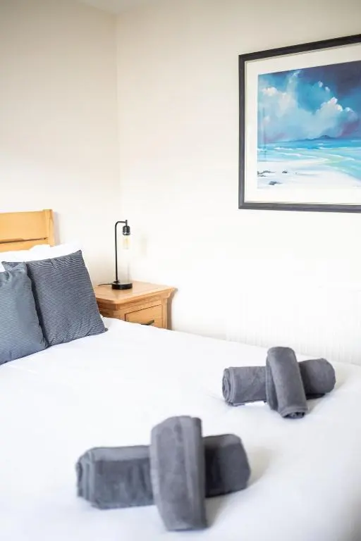 a white bed with two gray pillows on it at City and Loch Ness Blend in Inverness