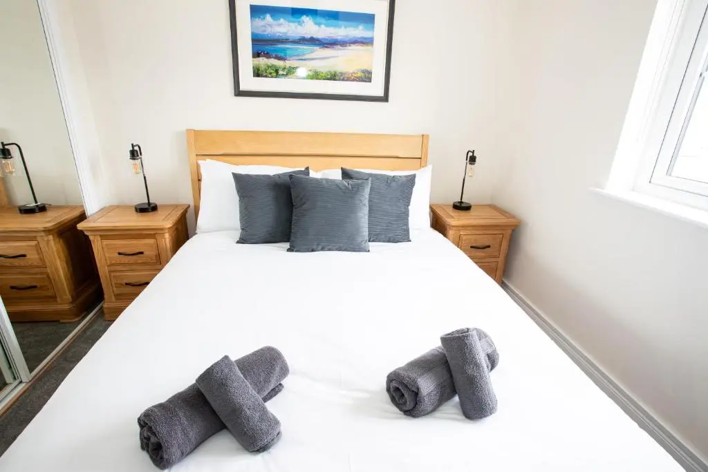 a bedroom with a white bed with two gray pillows at City and Loch Ness Blend in Inverness