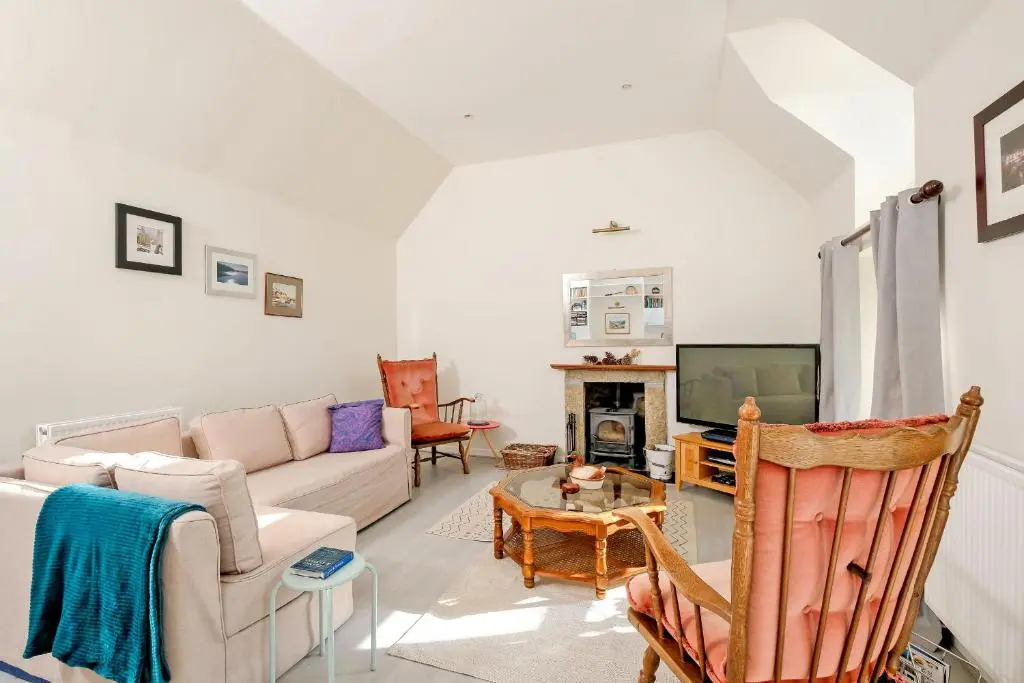 a living room with a couch and a tv at Finest Retreats - Corrennie School Cottage in Inverurie