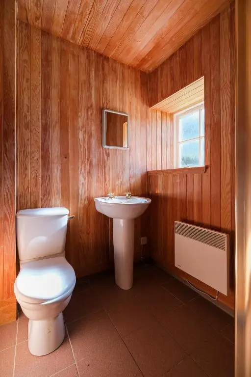a bathroom with a toilet and a sink at Gledfield Estate Holiday Cottages in Lower Gledfield