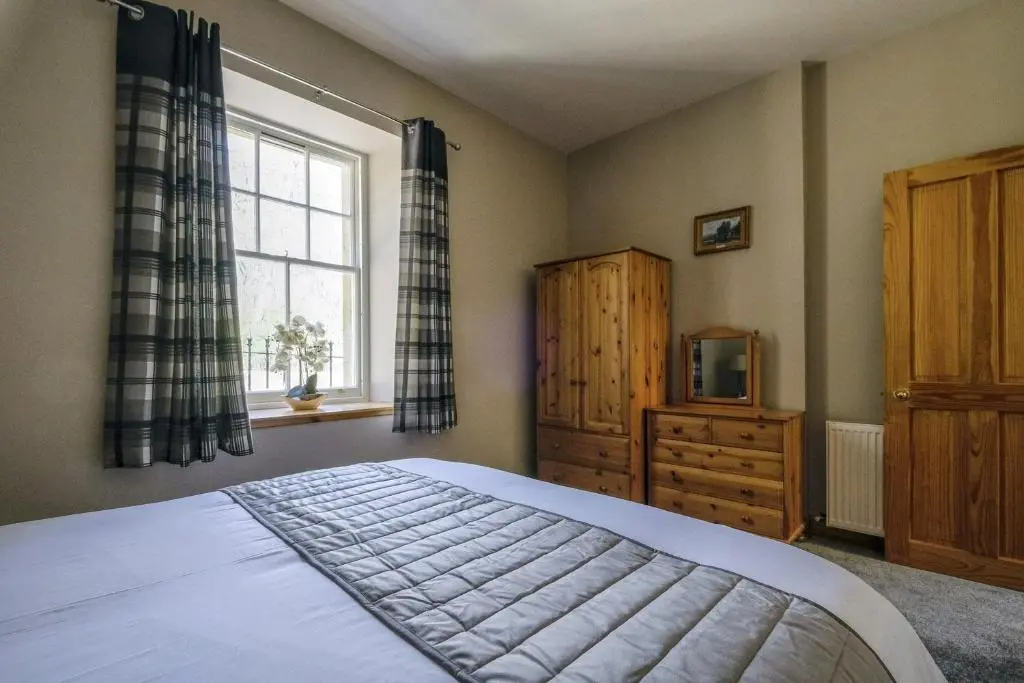 a bedroom with a bed and a window at Gledfield Estate Holiday Cottages in Lower Gledfield
