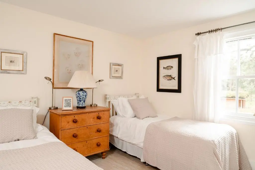 a bedroom with two beds and a dresser and a window at Glencarnie - Seasgair Lodges in Boat of Garten