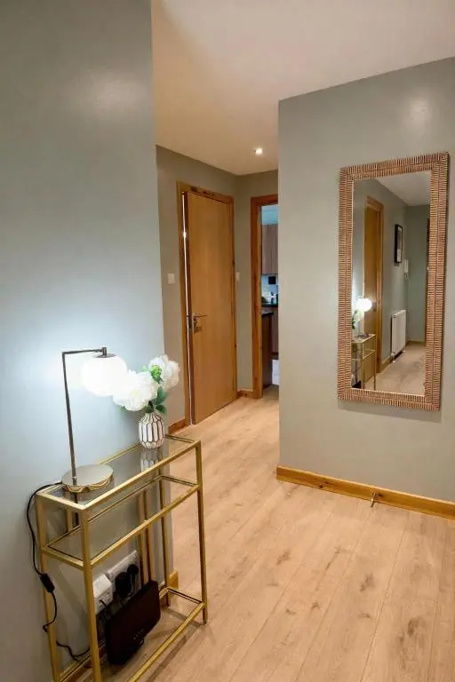 a living room with a table and a mirror at The Inver Nest in Inverness