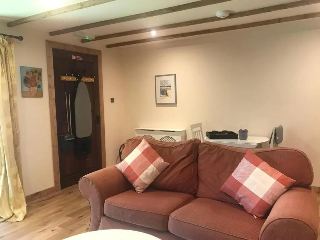 a living room with a brown couch in a room at Cosy Apartment in the Highlands in Muir of Ord