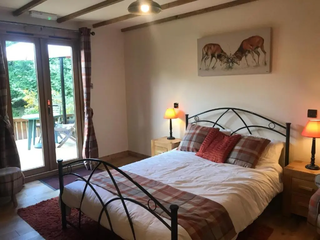 a bedroom with a large bed with red pillows at Cosy Apartment in the Highlands in Muir of Ord