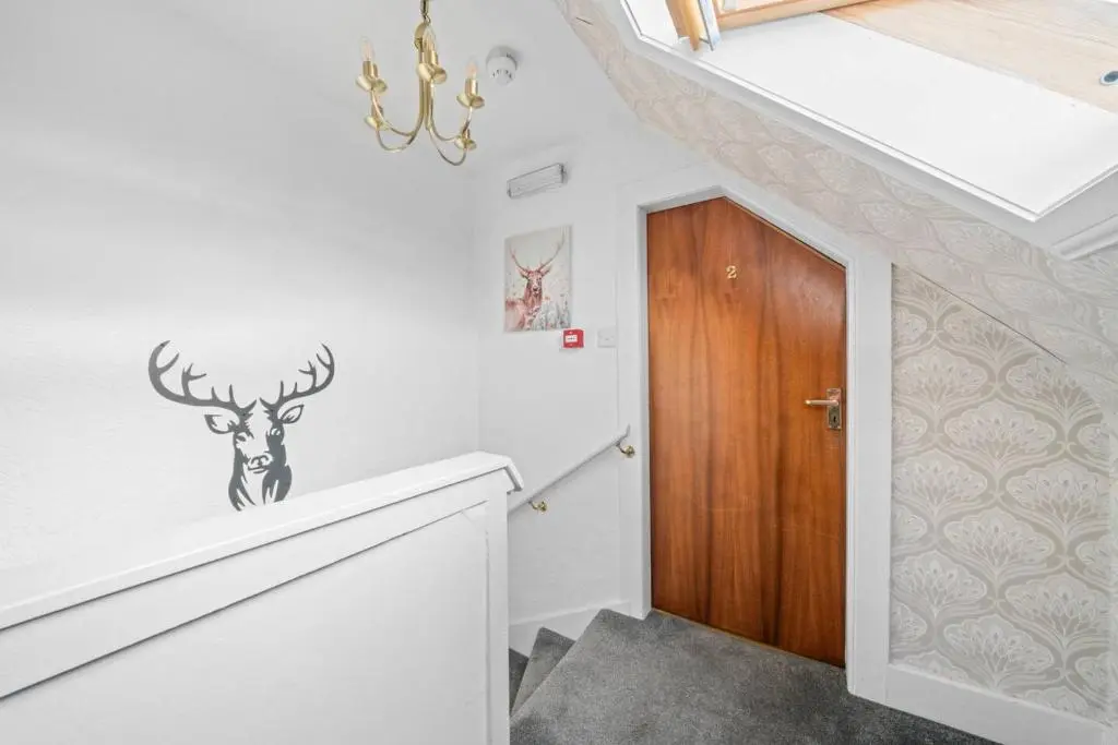 a hallway with a door with a deer decal on the wall at Cloudhowe Cottage Ensuite Rooms & Studio Inverness in Inverness