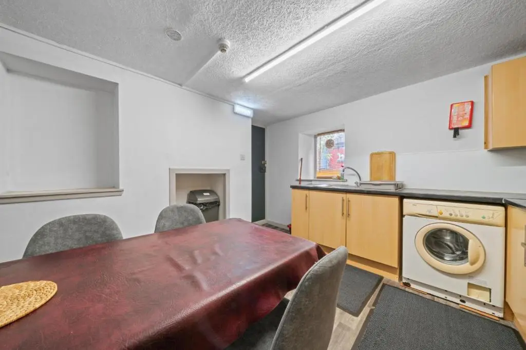 a kitchen with a table and a washing machine at Haugh 4 Bedroom House - Inverness in Inverness
