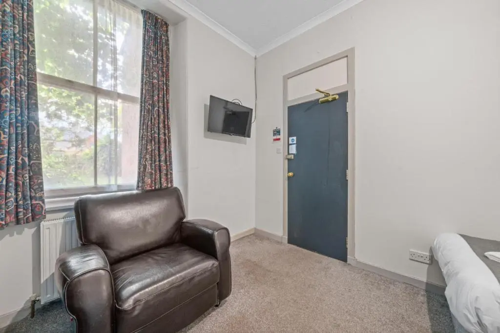 a bedroom with a leather chair and a window at Central Inverness Hideaway - 2 Bedroom Flat in Inverness