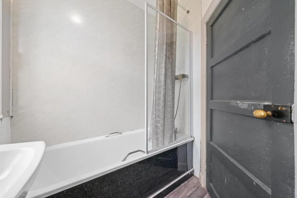 a bathroom with a glass shower door and a sink at Central Inverness Hideaway - 2 Bedroom Flat in Inverness