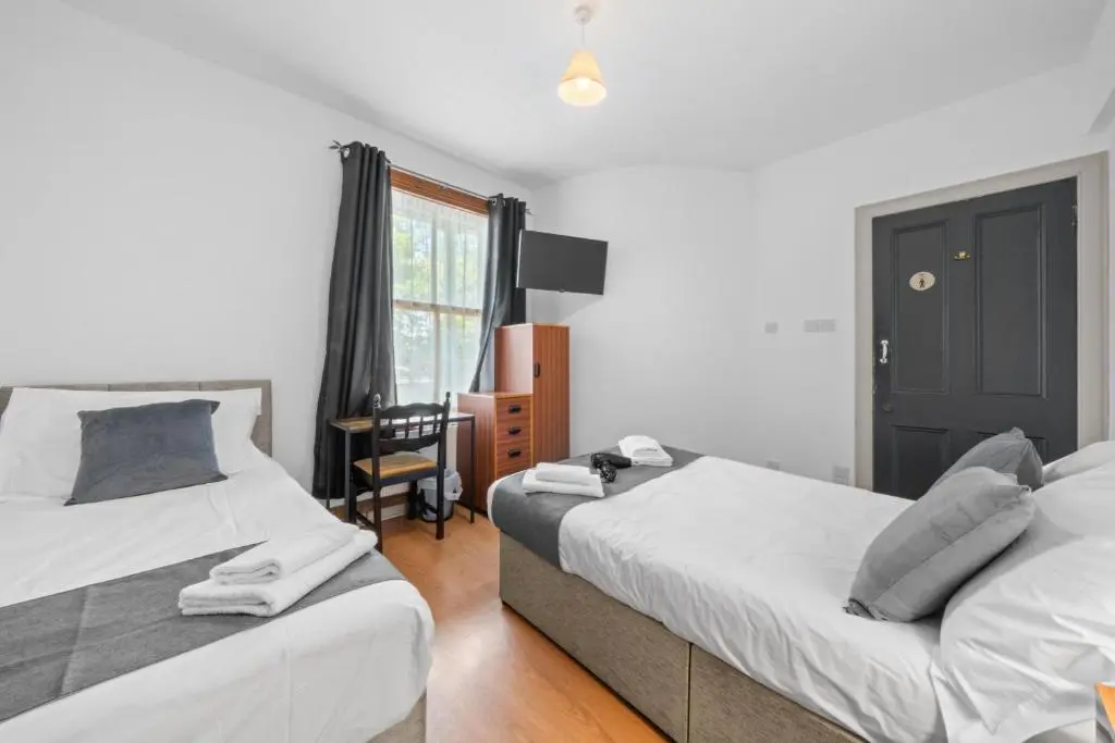 a bedroom with two beds and a desk and a window at 2 Bedroom Inverness Apartment - Perfect Location in Inverness