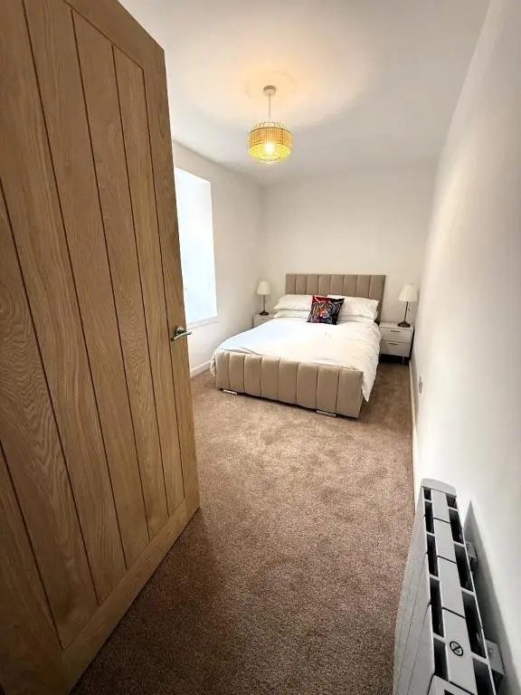 a bedroom with a bed and a large door at Meadowside-Stylish Newly Renovated 2 bed property in Insch