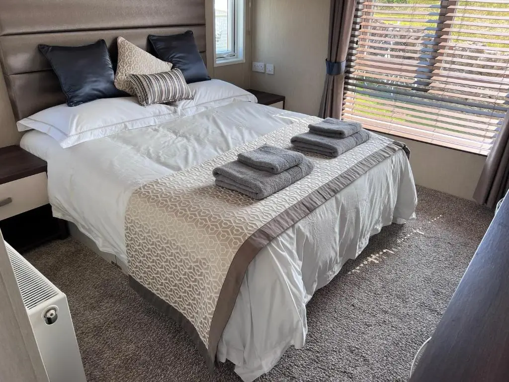 a bedroom with a bed with towels on it at Drift Lodge in Tain