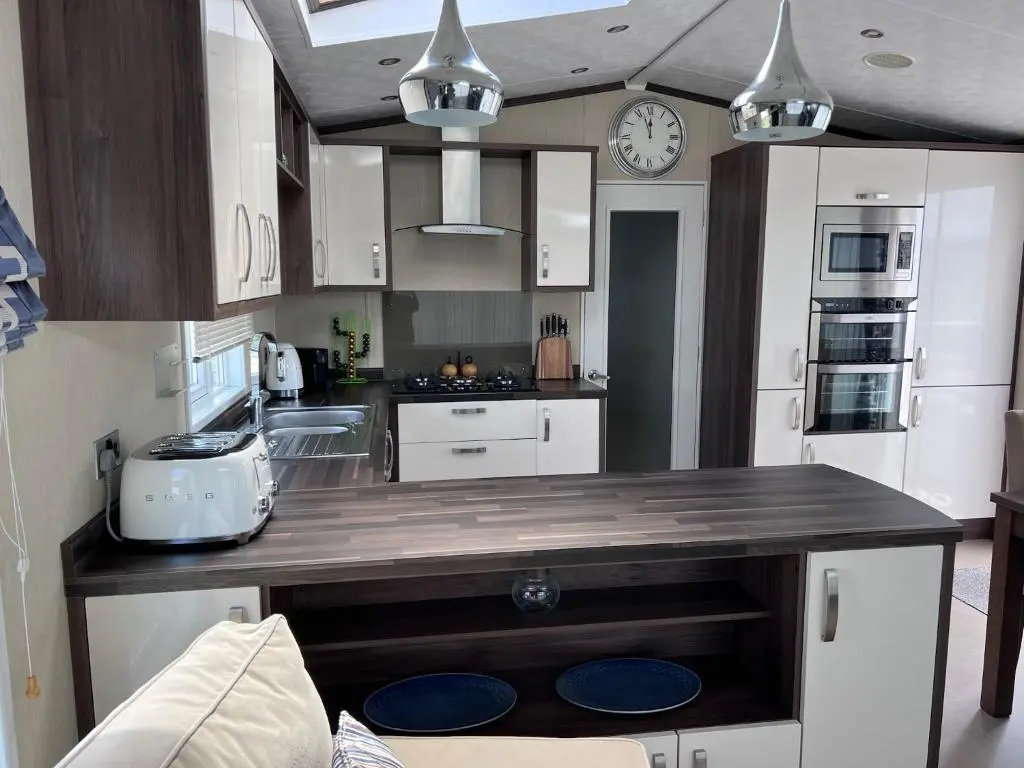 a kitchen with a large wooden counter top with a clock at Drift Lodge in Tain