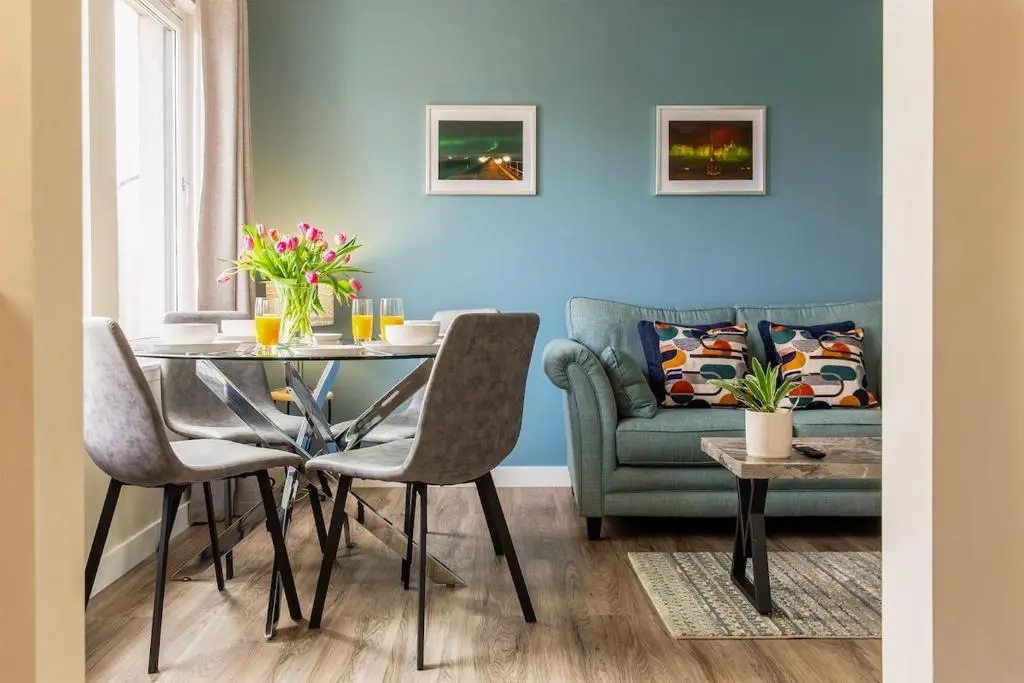 a living room with a table and a couch at River views 5 mins from beach in Nairn