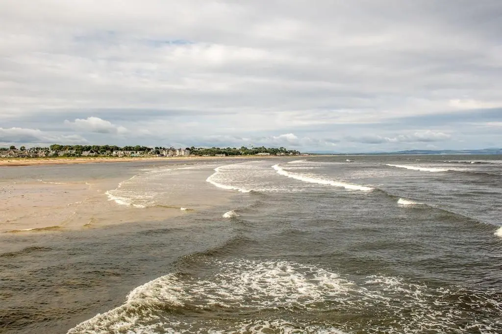 a beach with waves coming in from the ocean at River views 5 mins from beach in Nairn