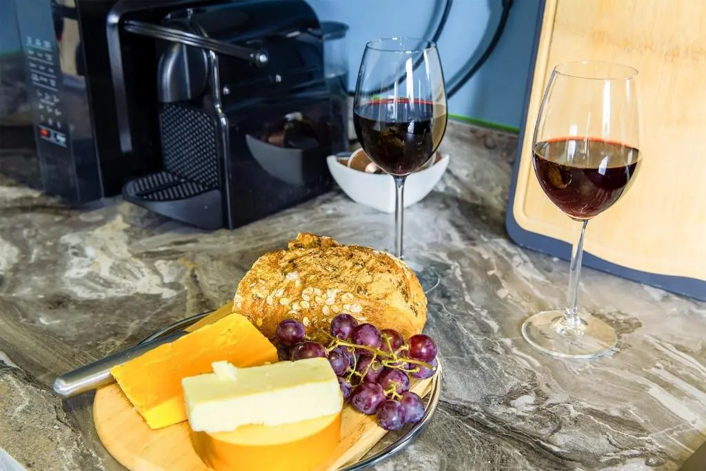 a plate of cheese and grapes and two glasses of wine at River views 5 mins from beach in Nairn
