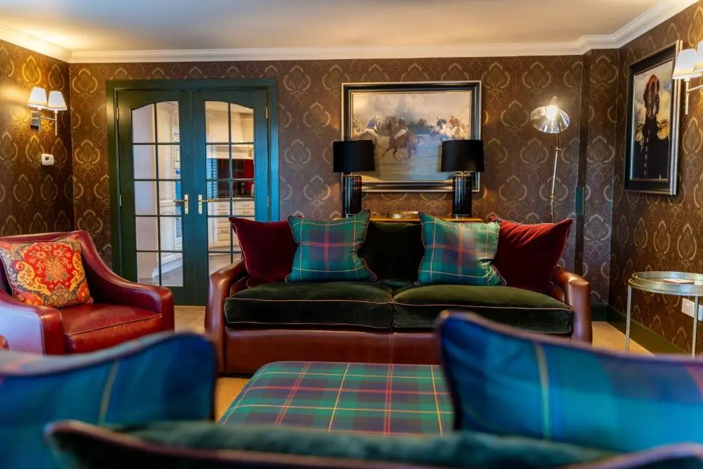 a living room with a couch and two chairs at The Old Coach House & The Hayloft in Braemar