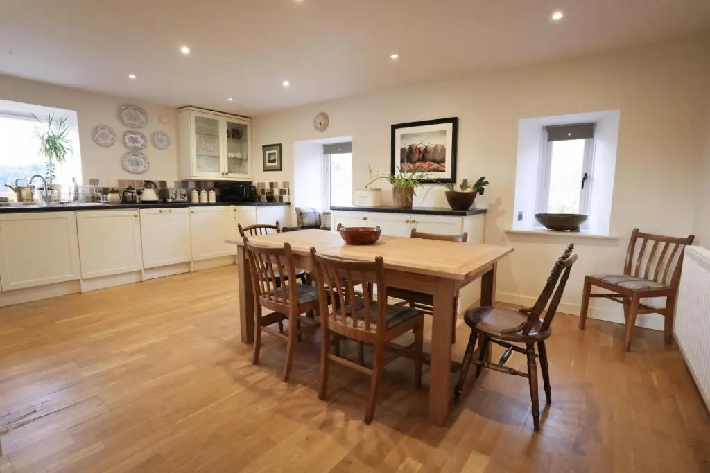a kitchen and dining room with a wooden table and chairs at Relugas Mill in Forres