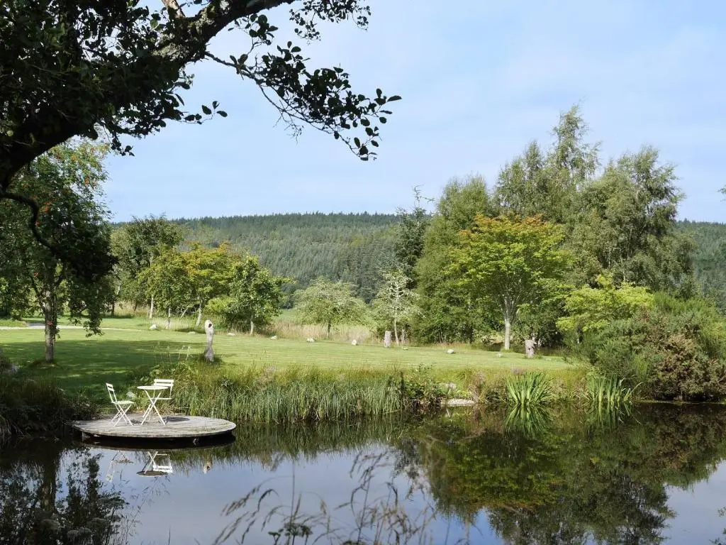 a table and chairs sitting on a pond in a park at Relugas Mill in Forres