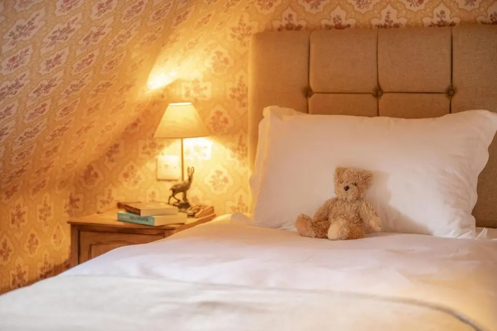 a teddy bear sitting on top of a bed at Laggandhu in Nethy Bridge