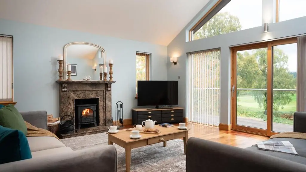 a living room with a couch and a fireplace at Coorie Lodge in Aviemore