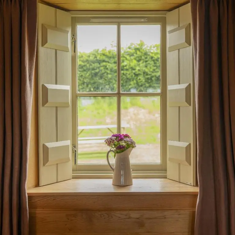 a vase with flowers sitting on a window sill at Drum Cottage in Nethy Bridge