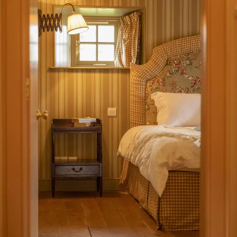 a small bedroom with a bed and a window at Drum Cottage in Nethy Bridge