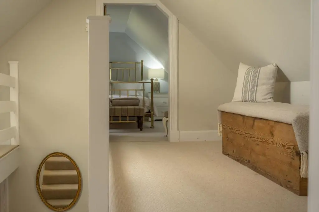 a bedroom with a bed with a mirror and a chair at Ellon Cottage in Nethy Bridge