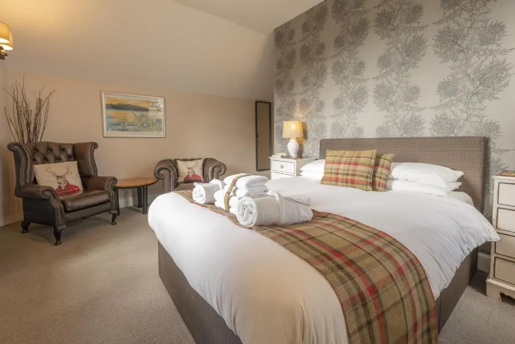 a hotel room with two beds and two chairs at Craggan Mill in Grantown on Spey