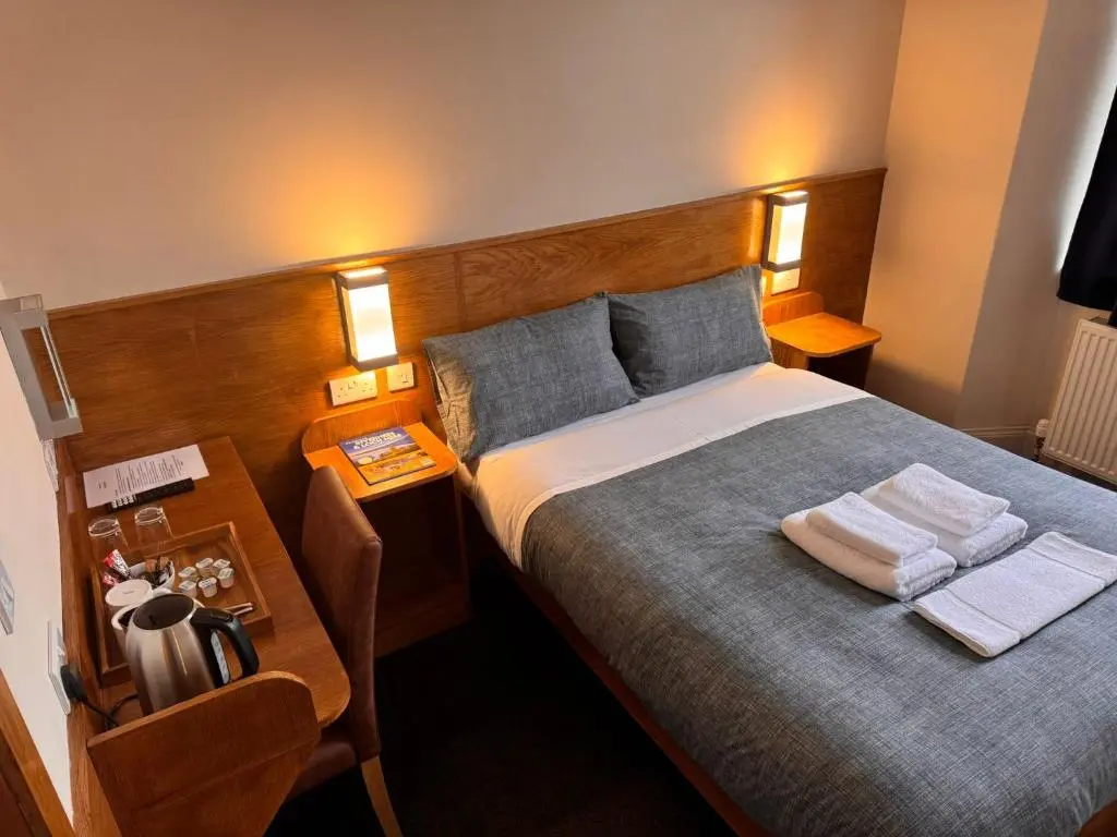 a bedroom with a bed with two towels on it at Bank House in Inverness