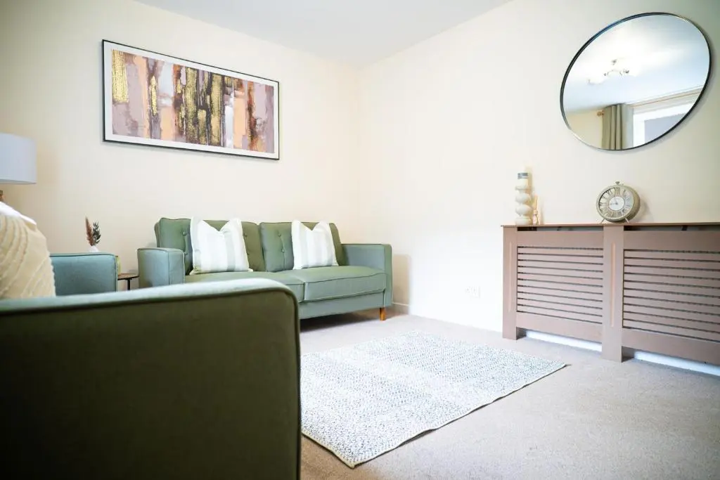 a living room with a couch and a mirror at Innes Street Apartment in Inverness